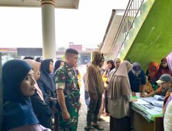 Babinsa Dampingi Ratusan Masyarakat Menerima Bantuan Beras